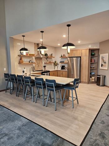 A modern kitchen with a long table and chairs.